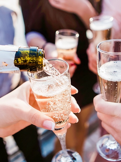 Pouring champagne into glasses at Cabaret La Nouvelle Eve spectacle.