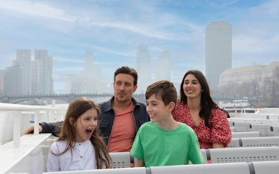 Family enjoying a London city cruise with skyline in the background.