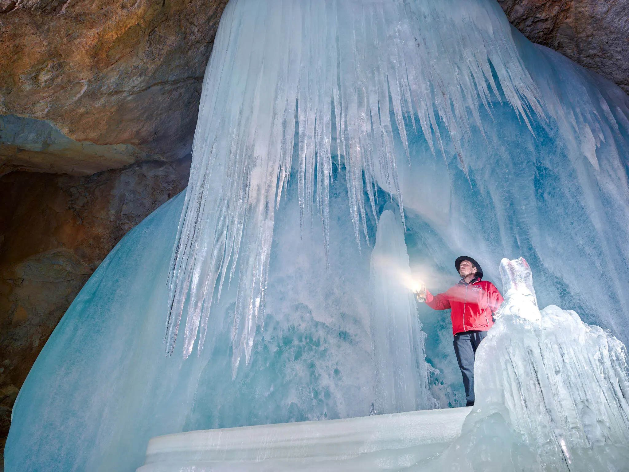 Guide exploring Werfen Ice Caves with lantern, Salzburg trip.