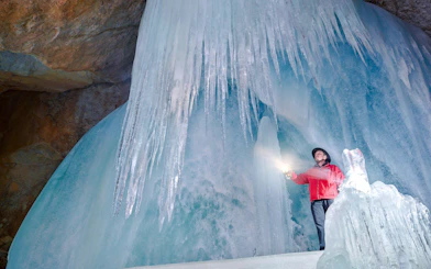 Guide exploring Werfen Ice Caves with lantern, Salzburg trip.