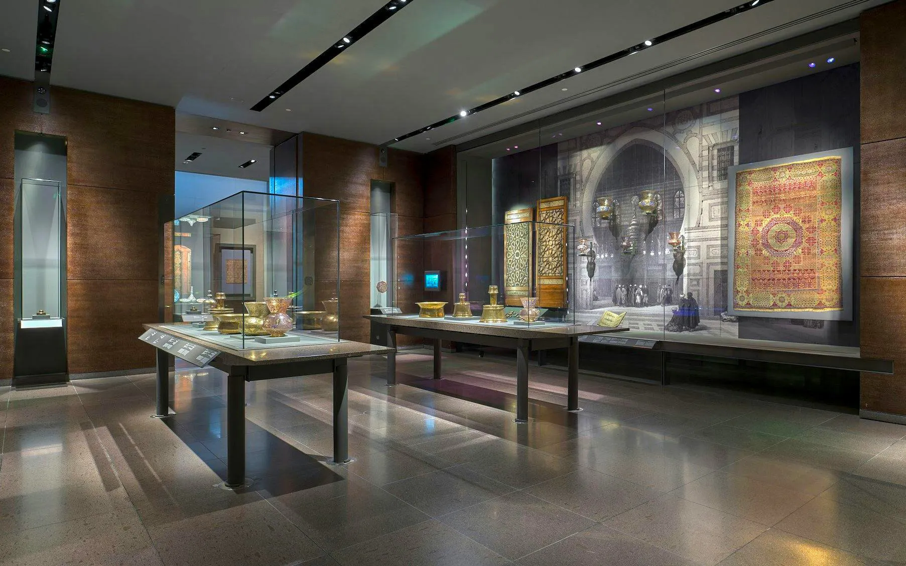 Exhibit of Islamic artifacts at the Museum of Islamic Art, featuring intricate metalwork and textiles.