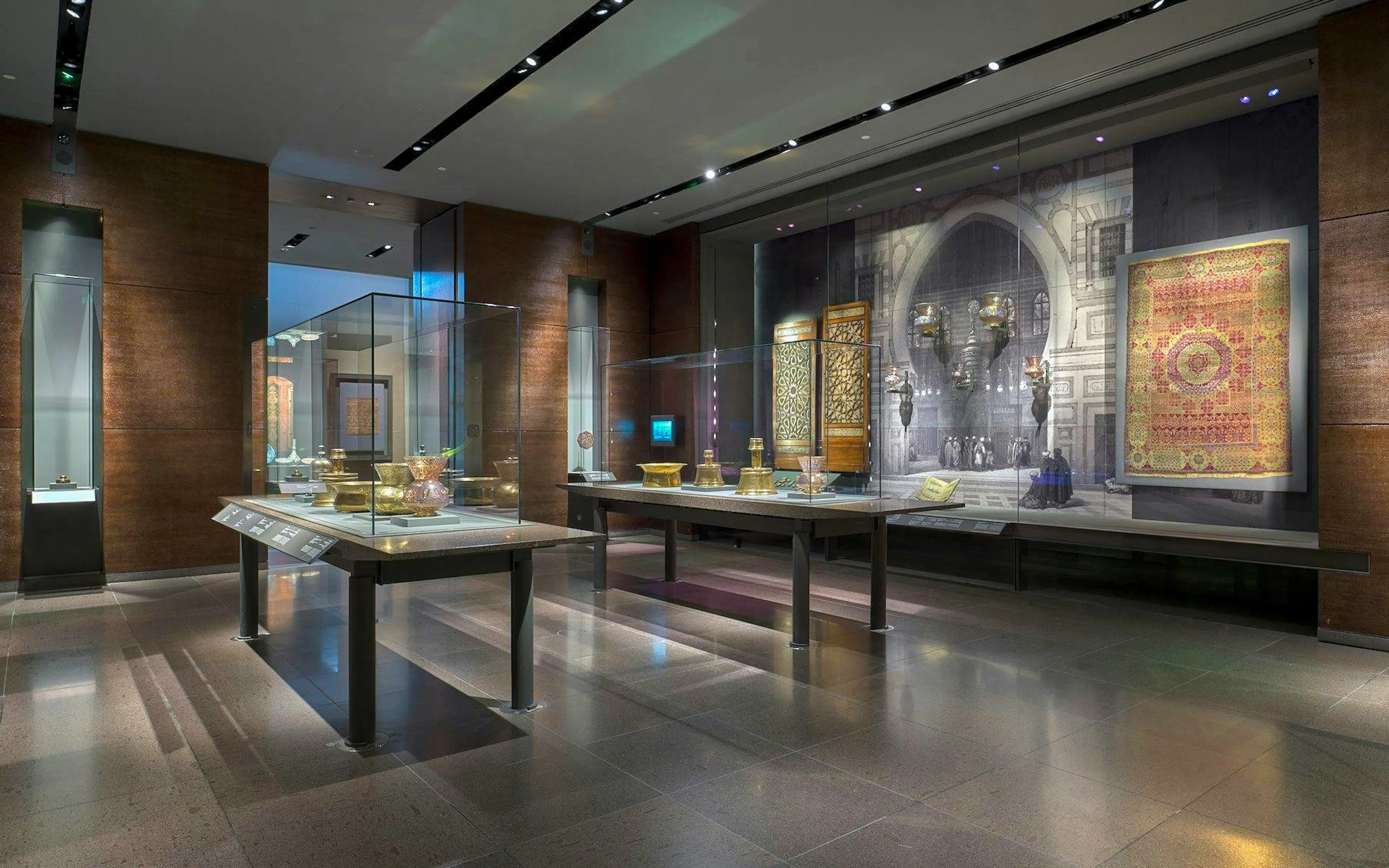 Exhibit of Islamic artifacts at the Museum of Islamic Art, featuring intricate metalwork and textiles.