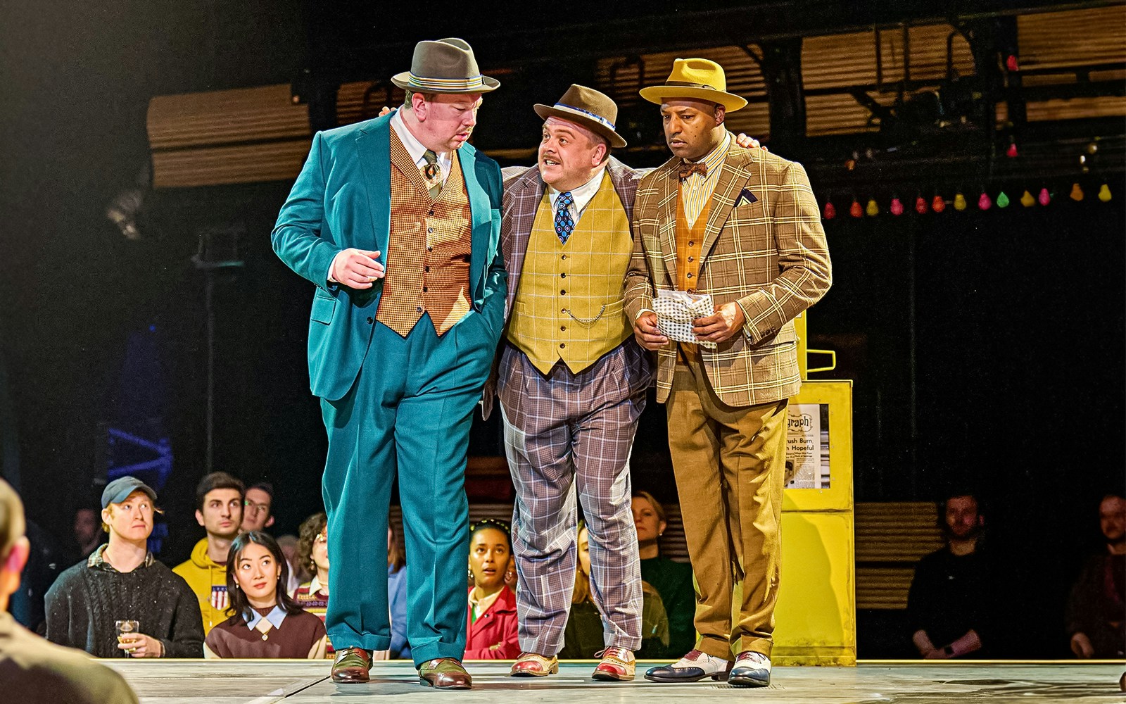 Three actors in 1950s attire perform a scene from "Guys & Dolls" on stage.