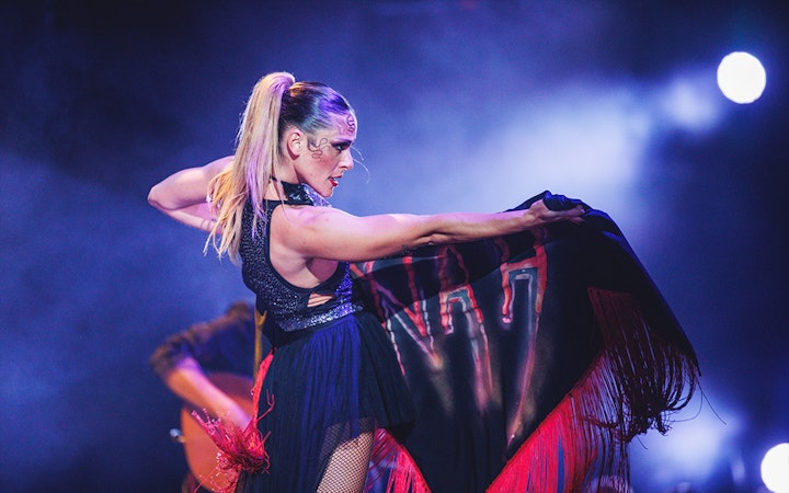 Performer on stage with a black and red shawl during a WAH show.