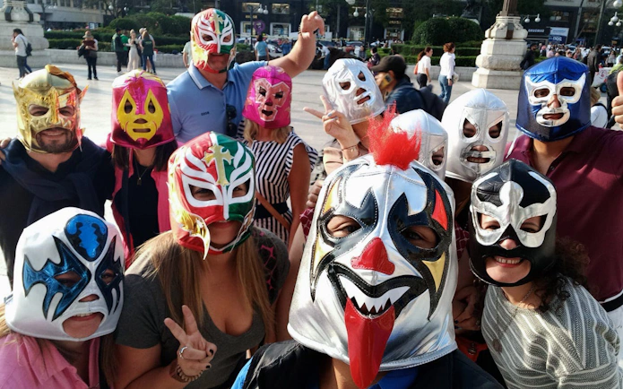 Group wearing colorful Lucha Libre masks at Arena Mexico.