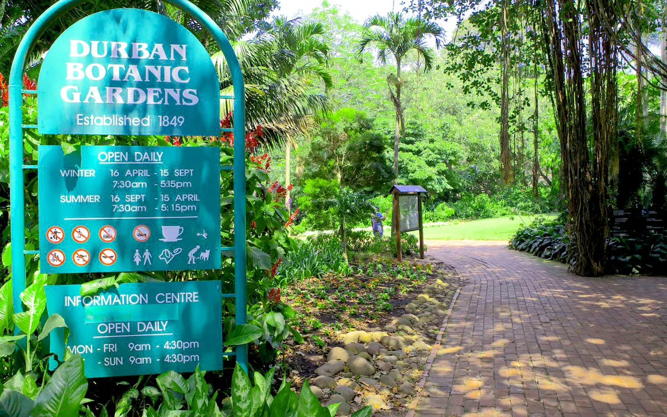 Durban Botanic Gardens entrance sign with lush greenery in Durban, South Africa.