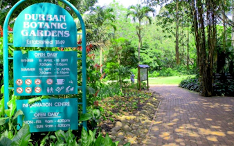 Durban Botanic Gardens entrance sign with lush greenery in Durban, South Africa.
