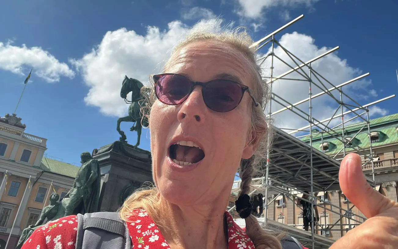 Person in front of Stockholm statue and scaffolding during city exploration game.