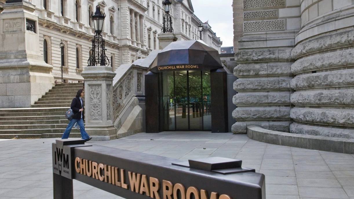 Entrance to Churchill War Rooms Museum in London with visitor walking nearby.
