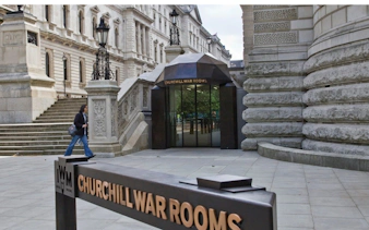 Entrance to Churchill War Rooms Museum in London with visitor walking nearby.
