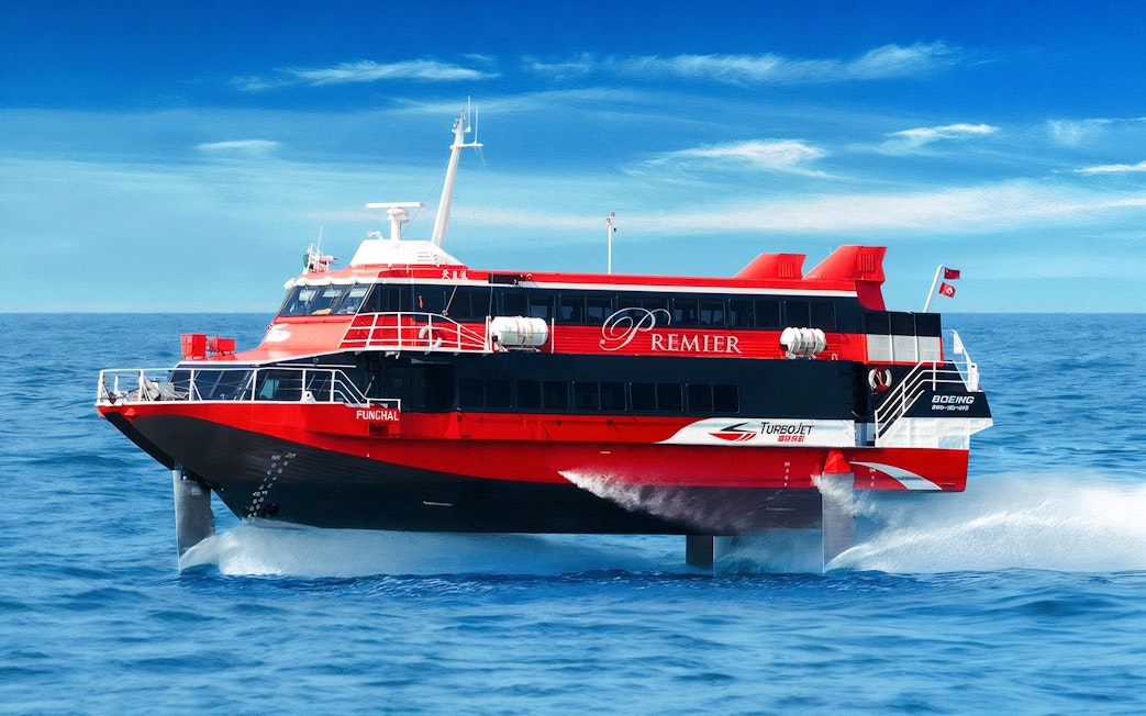 TurboJET ferry cruising from Macau to Hong Kong Island on open sea.