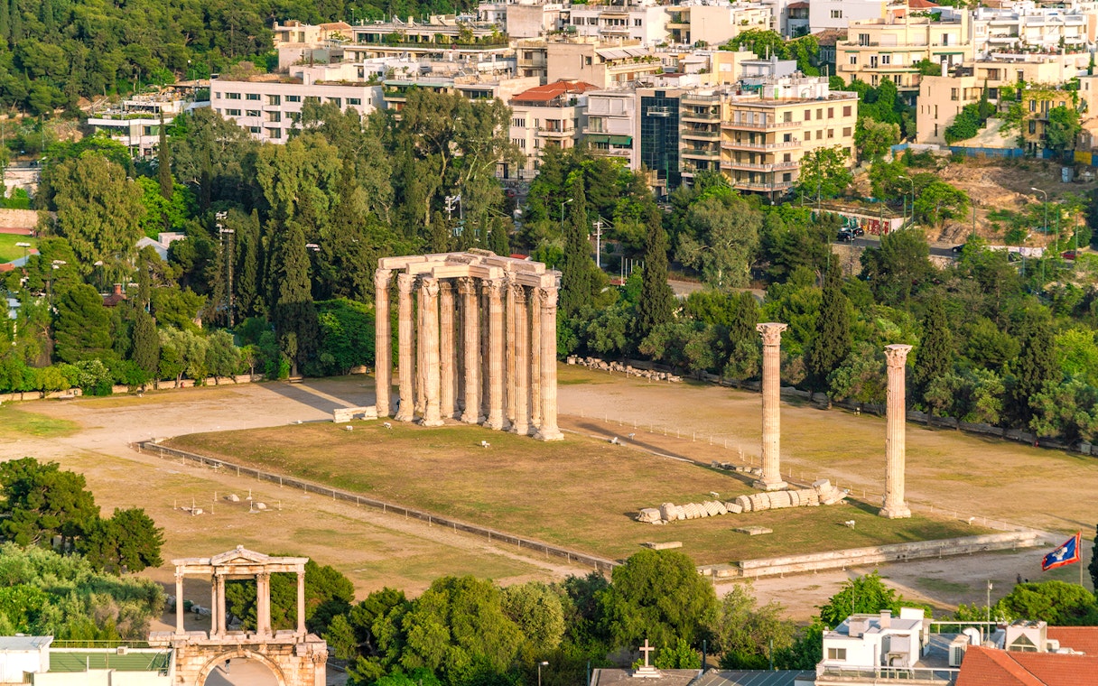 Temple of Olympian Zeus ruins in Athens with surrounding cityscape.