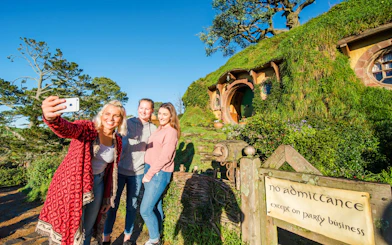 Visitors taking a selfie at Bag End hobbit house, Hobbiton Movie Set, New Zealand.