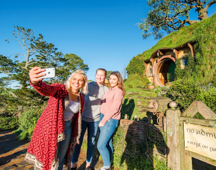 Visitors taking a selfie at Bag End hobbit house, Hobbiton Movie Set, New Zealand.