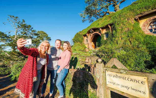 Visitors taking a selfie at Bag End hobbit house, Hobbiton Movie Set, New Zealand.