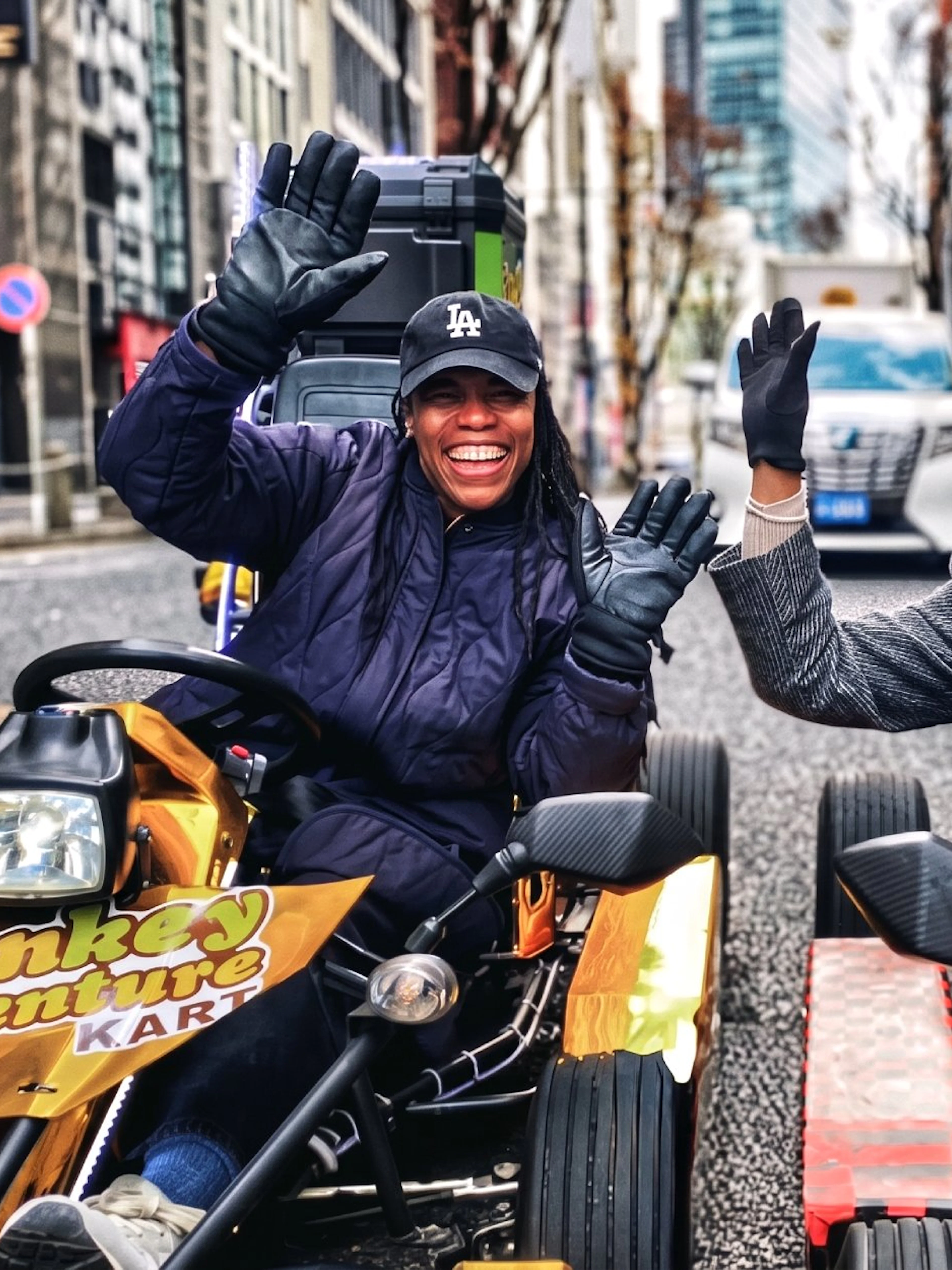 Go-kart riders smiling on Tokyo street during Shibuya to Shinjuku tour.