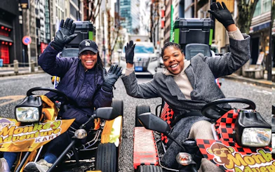 Go-kart riders smiling on Tokyo street during Shibuya to Shinjuku tour.