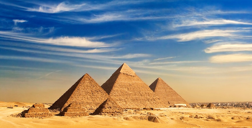 Pyramids of Giza under a clear blue sky in Cairo, Egypt.