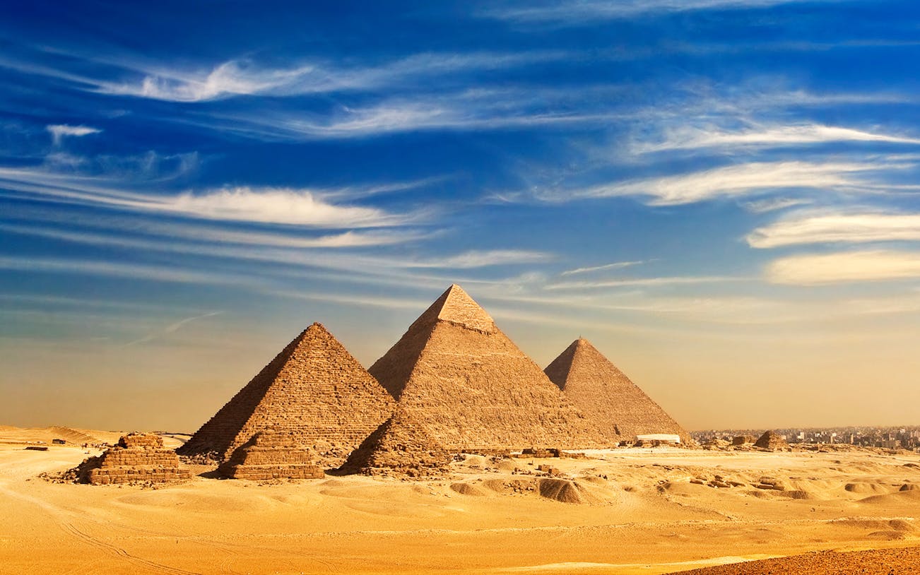 Pyramids of Giza under a clear blue sky in Cairo, Egypt.