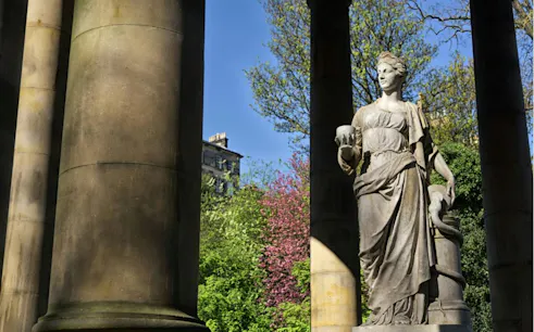 Statue surrounded by columns in a garden, part of Romantic Edinburgh self-guided city exploration game.