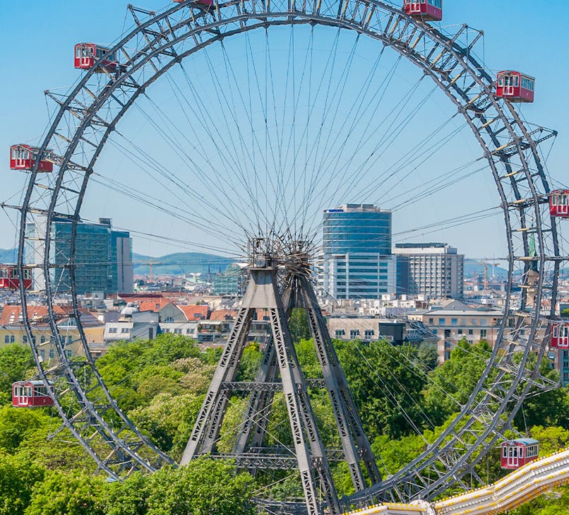 Vienna Giant Ferris Wheel at Prater amusement park with city skyline in the background
