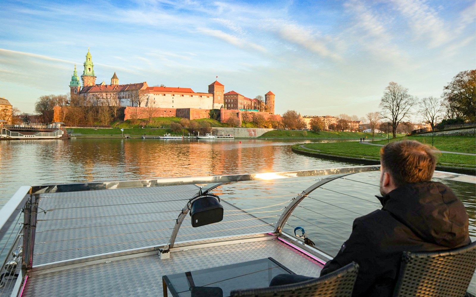 Guest viewing Wawel Castle from catamaran on Vistula River Cruise, Krakow.