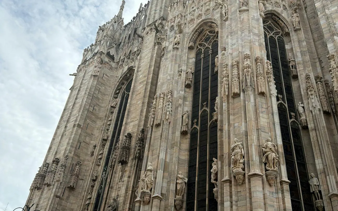 Gothic architecture of Milan Cathedral, featuring ornate statues and spires, part of the self-guided city exploration game.