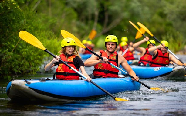 Group rafting on a river near Split, Croatia, wearing helmets and life vests.