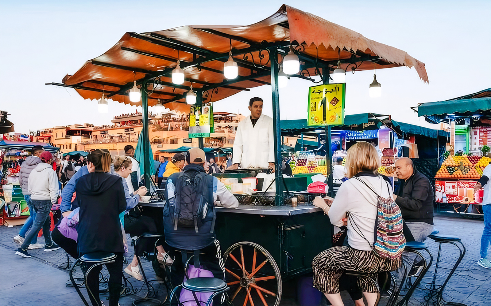 Visitors seated at a food stall in Jemaa el-Fnaa during a Marrakech night walking tour.