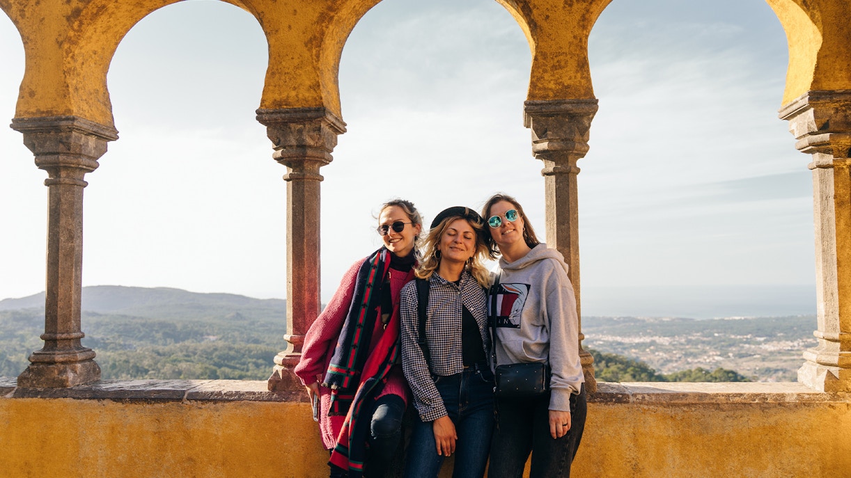 Tourists enjoying the view from Pena Palace arches in Sintra, Lisbon, Portugal.