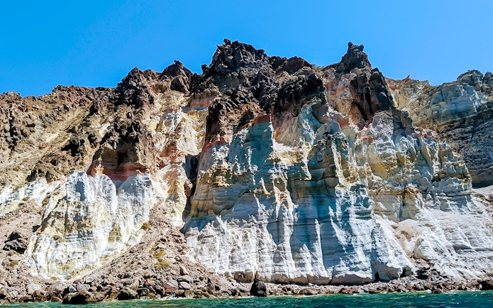 Santorini volcanic cliffs viewed from a private sailing catamaran cruise.