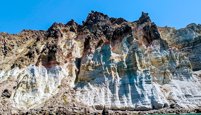Santorini volcanic cliffs viewed from a private sailing catamaran cruise.