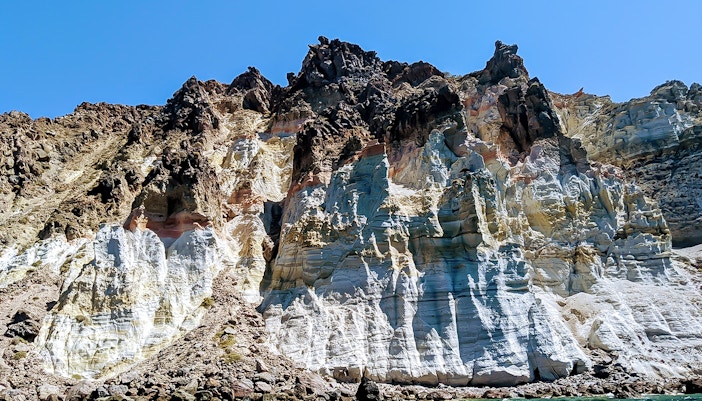 Santorini volcanic cliffs viewed from a private sailing catamaran cruise.