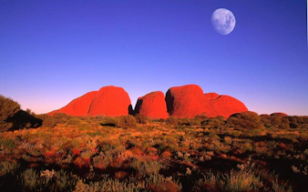 Kata Tjuta rock formations under a clear sky with a visible moon, Alice Springs tour.