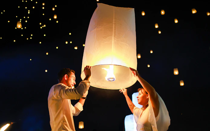 Releasing a sky lantern at Chiang Mai Sky Lanterns Festival, Thailand.
