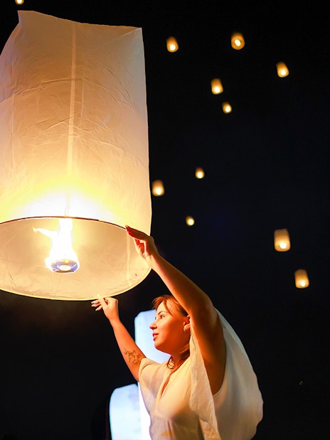 Releasing a sky lantern at Chiang Mai Sky Lanterns Festival, Thailand.