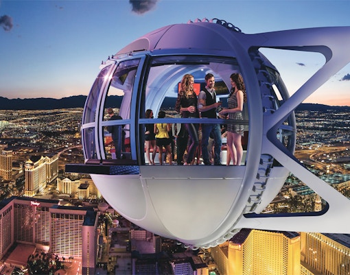 Guests enjoying the view inside the Las Vegas High Roller Observation Wheel at night.
