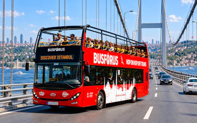 Open-top tour bus crossing Bosphorus Bridge in Istanbul.
