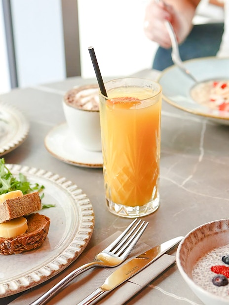 Breakfast spread at Sky Garden with croissant, chia pudding, orange juice, and bread with cheese.
