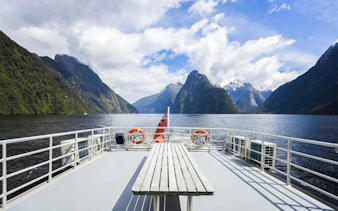 Cruise deck view of Milford Sound fjords in New Zealand with clear skies.
