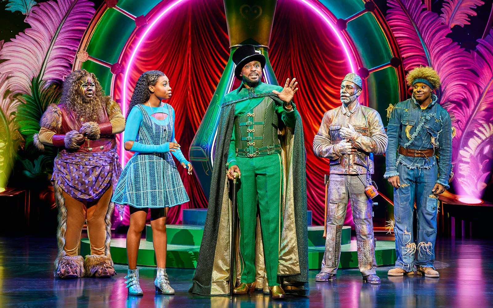 Cast of The Wiz performing on stage in colorful costumes.