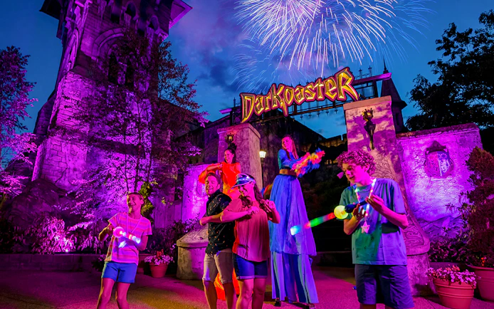 Busch Gardens Williamsburg Darkoaster ride with fireworks and performers at night.