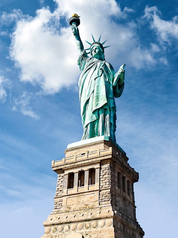 Statue of Liberty against blue sky, New York City.