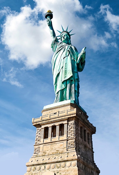 Statue of Liberty against blue sky, New York City.