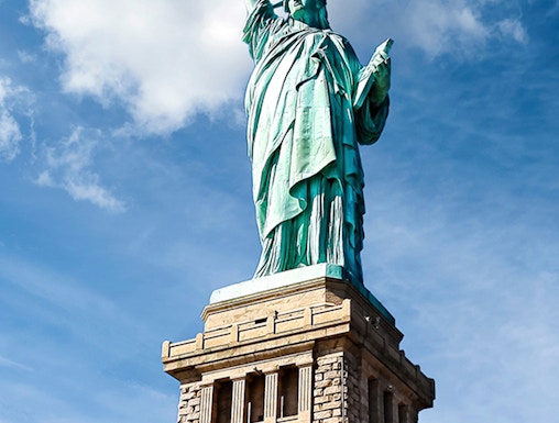 Statue of Liberty against blue sky, New York City.
