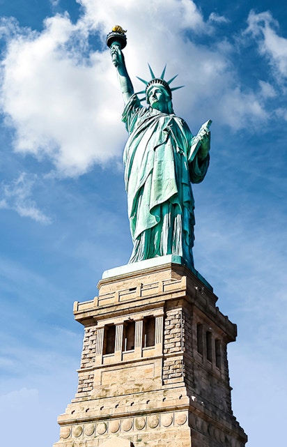 Statue of Liberty against blue sky, New York City.