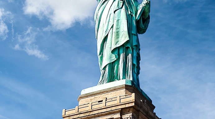 Statue of Liberty against blue sky, New York City.