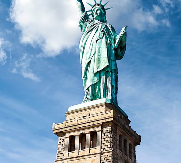 Statue of Liberty against blue sky, New York City.