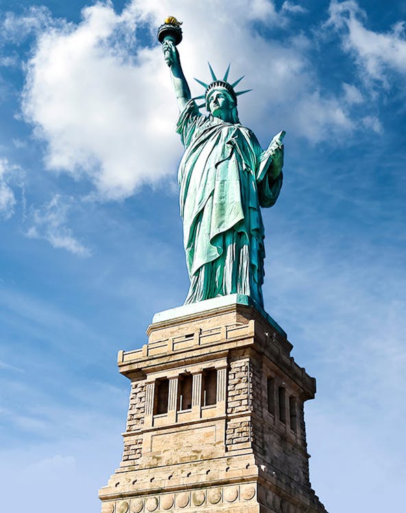 Statue of Liberty against blue sky, New York City.