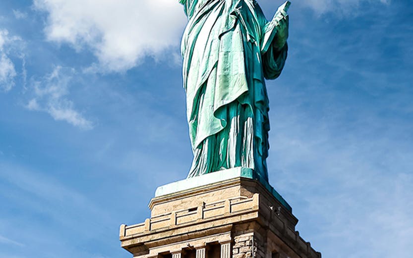 Statue of Liberty against blue sky, New York City.